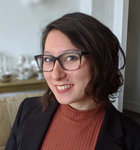 Photo of doctoral candidate Mika Thornburg, with short brown hair and wearing glasses.